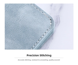 Macro shot of precise cream stitching on a slim light blue leather card holder wallet