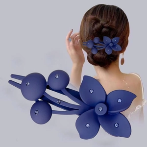 Detail of navy blue matte hair clip with floral design and rhinestones on model