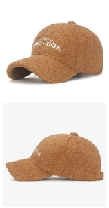 Close-up of brown teddy fleece fabric and white embroidery on the baseball cap