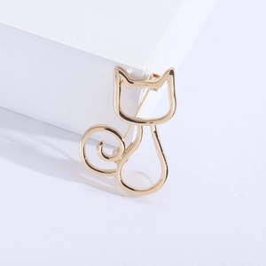 Makroaufnahme einer minimalistischen goldenen Katzenbrosche mit glatter Oberfläche