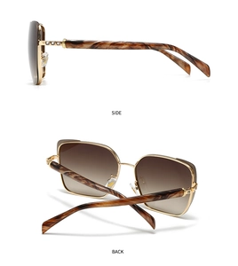 Detail view of gold metal sunglasses with tortoiseshell temples and brown gradient lenses