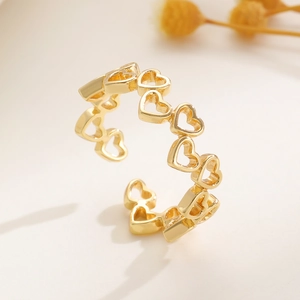 Makro-Detail eines verstellbaren goldfarbenen Rings mit verbundenen hohlen Herzmotiven
