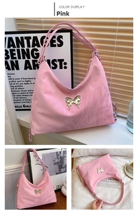 Detail of pink crescent bag with embossed texture and metal butterfly decoration