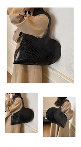 Detailed views of a black crocodile texture heart-shaped tote bag in a fashion street style