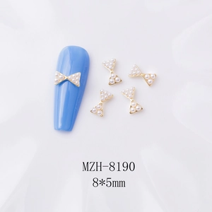 Vue détaillée des bijoux de nœud perle dorée 8x5mm pour ongles sur fond blanc