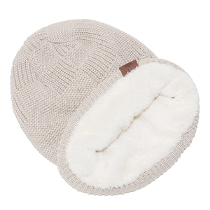 Primo piano del berretto in maglia beige con calda fodera in pile bianco spesso