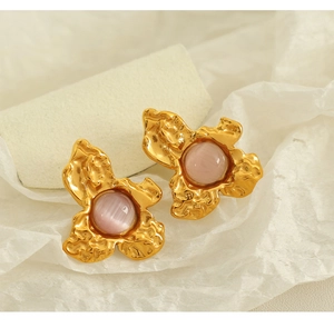 Detail of vintage gold flower earring with pink cabochon and irregular texture