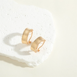 French vintage style 14K gold plated striped curved earrings on a white stone base
