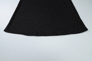 Détail de l'ourlet de la robe noire avec des embellissements en strass argentés