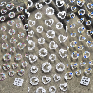 Detailed macro view of 3D heart and round holographic crystal nail art stickers