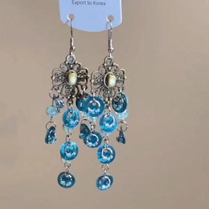 Details von Vintage-Silberohrringen mit Blumenmotiven und blauen Quasten-Anhängern