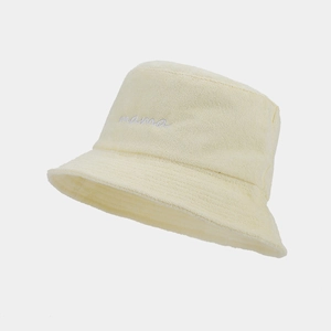 Close-up of white 'mama' embroidery on a beige terry cloth bucket hat texture