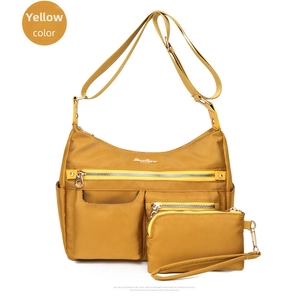 Detail view of yellow water-resistant nylon crossbody bag with mini zip pouch attachment
