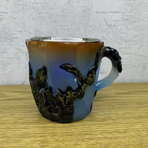Macro detail of a mineral crystal mug with brown-blue gradient glaze and rock texture