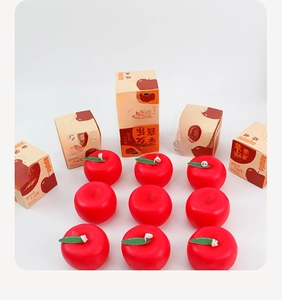 Detalle de velas perfumadas de manzana roja con cajas de regalo Good Luck en rejilla