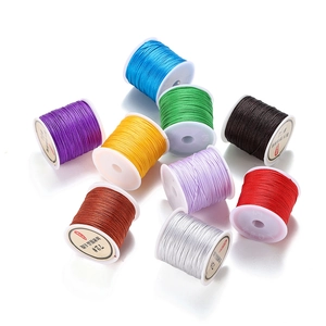 Flat lay of multiple colorful 72# polyester cord spools for DIY jewelry making