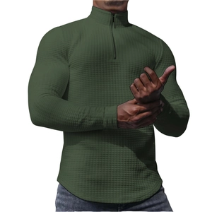 Detail of dark green waffle knit fabric texture and stand collar with quarter zipper