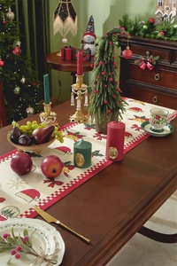 Christmas table runner with festive bell and hat patterns on a rustic wooden table