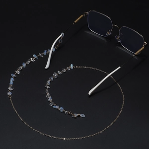 Handmade gold chain glasses strap with blue-white translucent opal stones on black backdrop