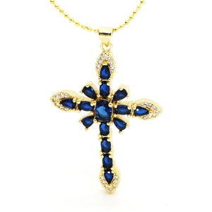 Detail of gold cross pendant with blue pear-cut gemstones and sparkling white crystals