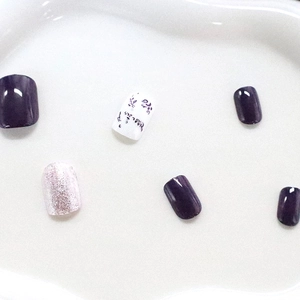 Short square press-on nails in purple gloss, silver glitter and floral leaf patterns