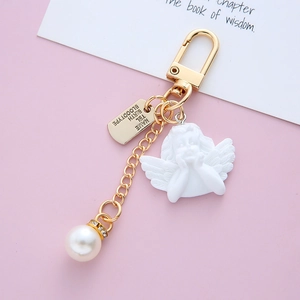 Baroque cupid angel keychain with pearl and heart charms on a pink aesthetic background