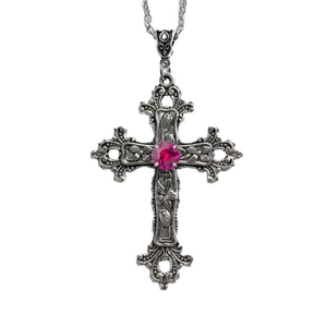Close-up of vintage silver gothic cross pendant with pink gemstone and floral engraving