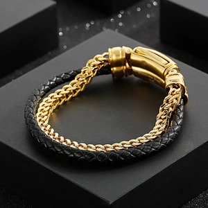 Detail of double-layer woven leather and gold stainless steel bracelet with clasp
