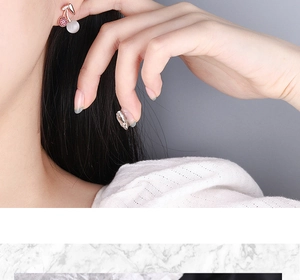 Detailed close-up of rose gold cherry stud earrings featuring pink crystals and white stones