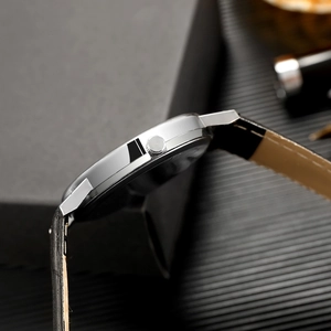 Side view showing the ultra-thin silver metal case and black leather strap of this watch