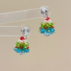 Macro view of beaded Christmas tree earrings with colorful crystals and alloy clips