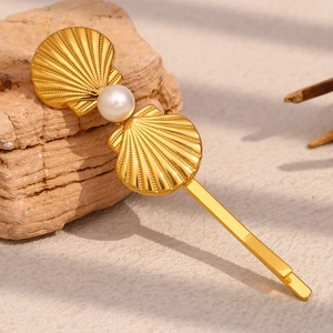 Detailed close-up of 18K gold-plated scallop hair clip with a centered white pearl