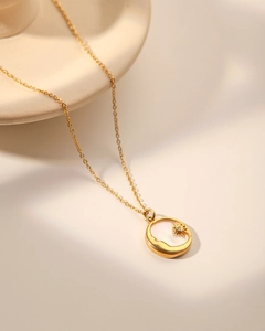 Gros plan détaillé d'un pendentif lune vintage plaqué or 18 carats avec une petite zircone