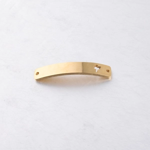 Close-up of curved golden stainless steel bar connector with hollow tree pattern detail