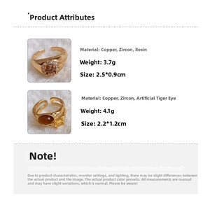 Detailed spec view of vintage gold plated oval tiger eye and resin open rings for women
