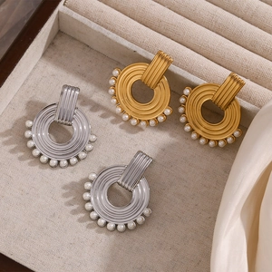 Close-up of gold and silver hoop earrings with pearls on a soft velvet jewelry tray