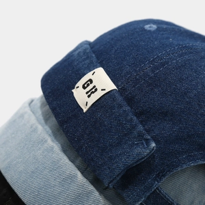 Detail of blue denim docker hats showing fabric texture and GR woven labels