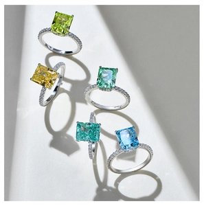 Macro shot of colorful emerald cut gemstone rings with sparkling diamond paved bands