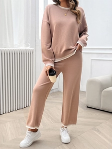 Detail of khaki knitted set featuring white stripe trim on cuffs and wide-leg hem