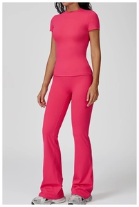 Close-up of pink high-stretch yoga set featuring short sleeve top and flared trousers