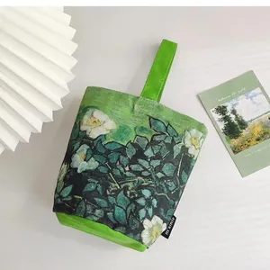 Detail of canvas bucket bag featuring Van Gogh floral art and sturdy green handle