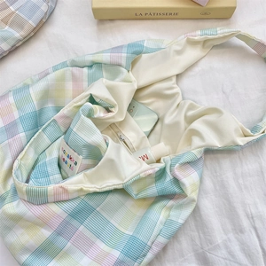 Detail view of plaid tote bag interior with zipper pocket for phones and cosmetics