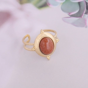 Macro detail of vintage gold twist ring featuring oval reddish-brown sandstone gem