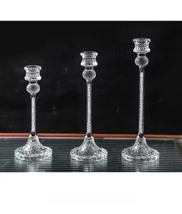 Detail of three crystal glass candle holders with faceted bases and crushed diamond pillars