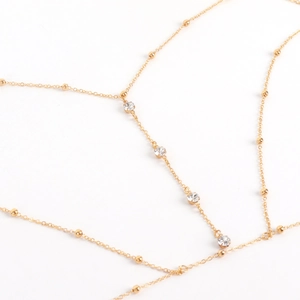 Detailed view of elegant gold body chain with shimmering rhinestones and beads