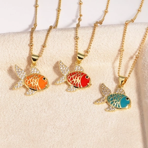 Detailed shot of three gold fish pendants with colorful enamel and sparkling rhinestones