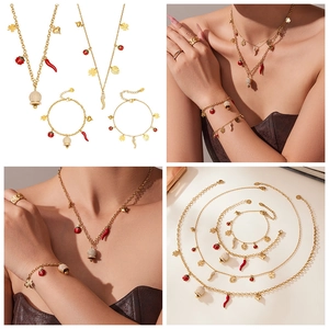 Vues détaillées de bijoux dorés avec des breloques piment rouge et trèfle portés