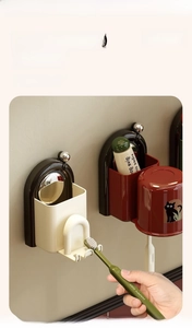 Detail of wall-mounted magnetic toothbrush holder with suction cups and cups in a bathroom