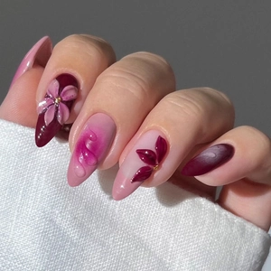 Close-up of 3D pink flowers and water drop textures on almond gradient press-on nails
