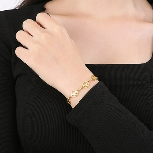 Collier doré aux maillons circulaires ajourés porté par un mannequin élégant